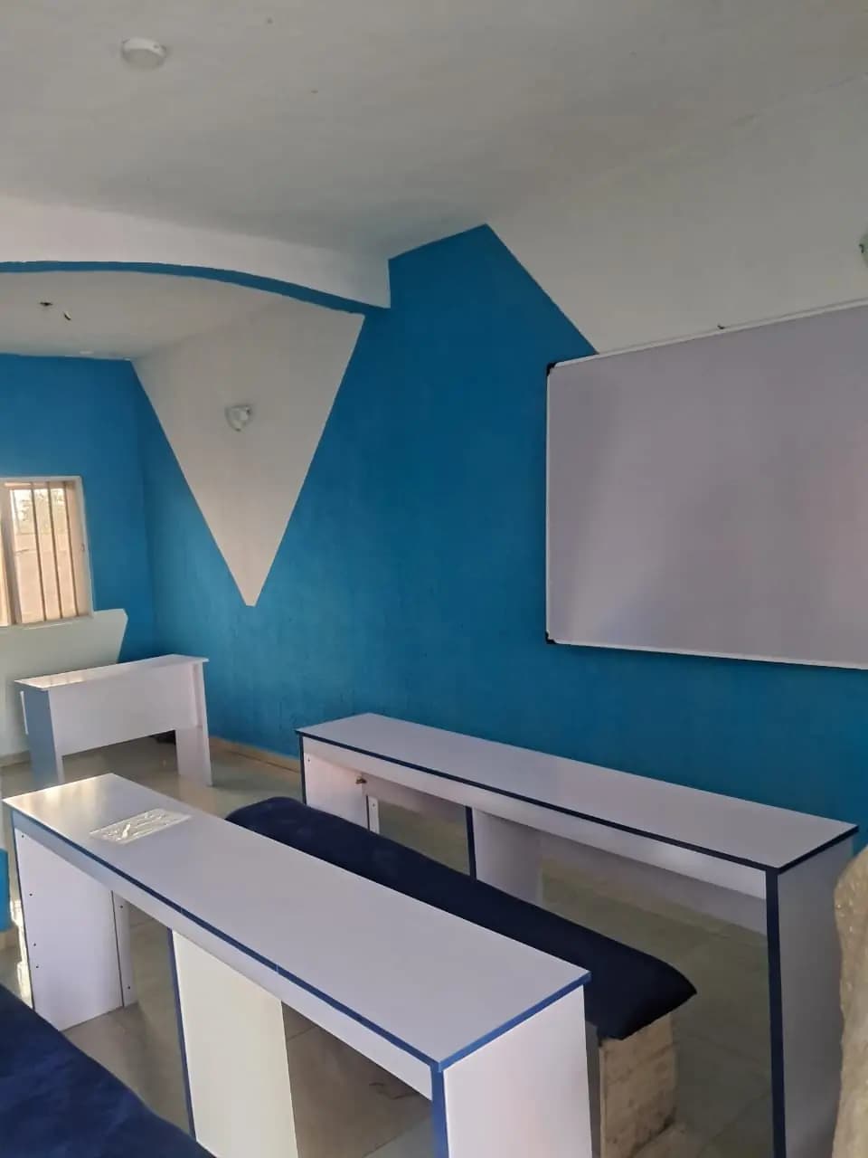 A Miracrest teaching room photographed by the school, showing the desks, the teaching wall and the whiteboard.