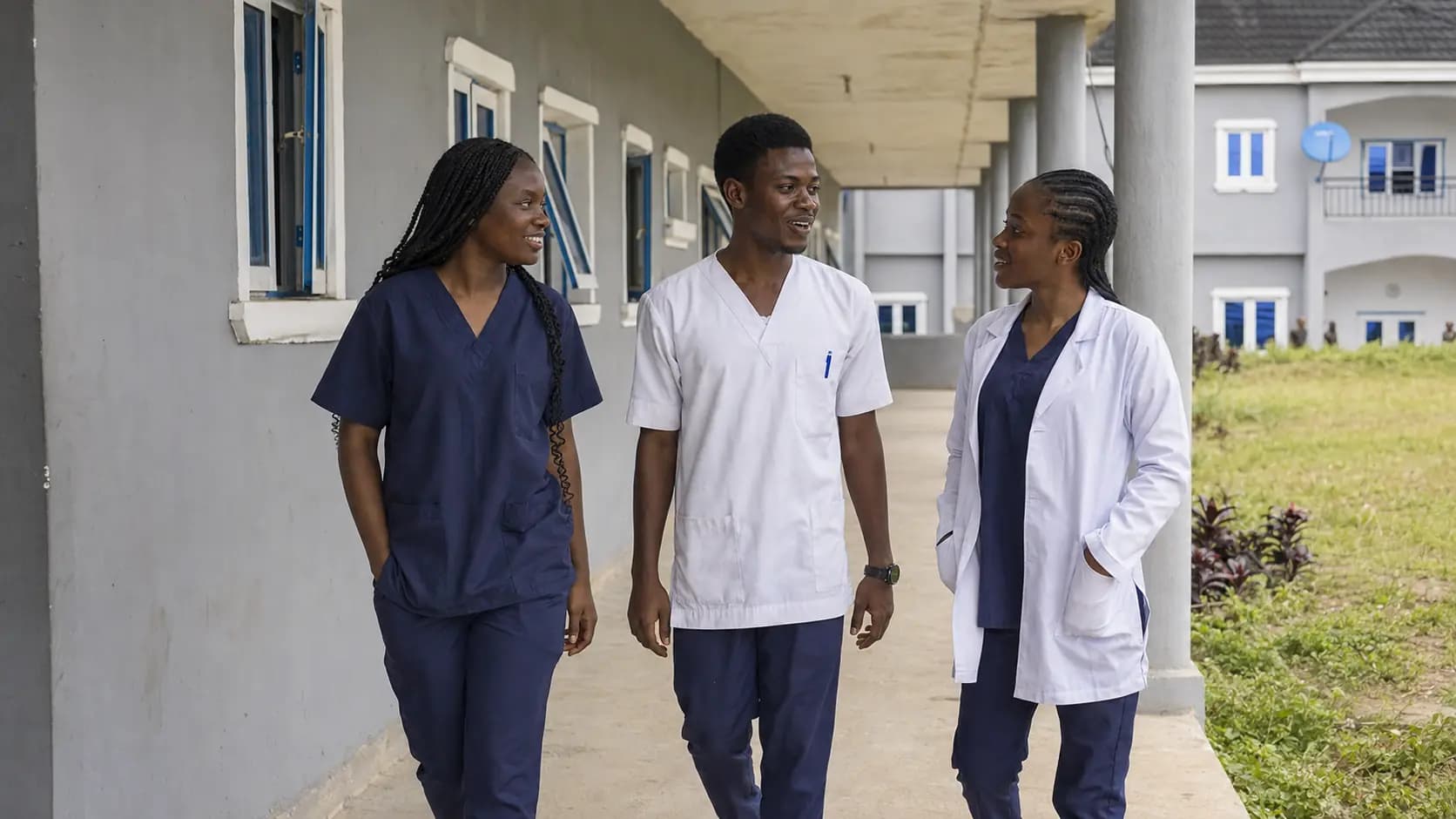 Students in navy and white uniforms walking together along a school walkway.